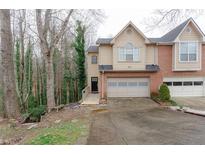 Inviting townhome showcasing a well-manicured lawn, attached garage, and neutral siding at 873 Edgewater Cir, Marietta, GA 30062