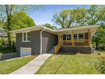 Charming grey brick home with a covered porch and well-maintained front yard at 2358 Larchwood Sw Rd, Atlanta, GA 30310