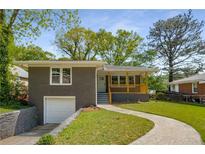 Charming brick home featuring a covered front porch, nicely landscaped lawn, and attached garage at 2358 Larchwood Sw Rd, Atlanta, GA 30310