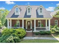 Charming brick home features a welcoming front porch and well-maintained landscaping at 675 Jack Page Ln, Canton, GA 30115