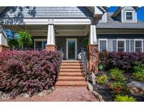 Charming home featuring a brick stairway and manicured landscaping leading to a welcoming covered front porch at 414 Pensdale Rd, Decatur, GA 30030