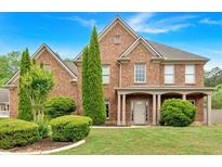 Charming brick two-story home with manicured lawn and mature landscaping at 900 Fox Croft Pl, Canton, GA 30114
