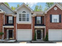 Charming brick townhomes featuring attached garages and manicured front entrances at 215 Morris Ln, Woodstock, GA 30188