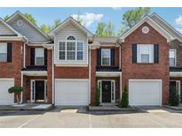 Charming brick townhouse with attached garage and well-maintained front yard at 215 Morris Ln, Woodstock, GA 30188
