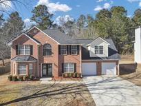 Charming two-story brick home features a two-car garage, manicured lawn, and classic curb appeal at 5854 Cobalt Dr, Powder Springs, GA 30127