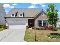 Charming brick and siding home with a well-manicured lawn and an attached two-car garage at 5520 Allegre Pl, Cumming, GA 30028