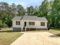 Charming single-story home with a well-maintained lawn, complemented by a concrete driveway and mature trees at 45 Carroll St, Temple, GA 30179