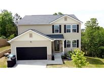 Charming two-story home with a black garage door, neutral siding, and neatly landscaped front yard at 11 Plymouth Ct, Kingston, GA 30145
