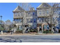 Attractive townhomes with two stories and well-maintained landscaping offer appealing curb appeal at 702 Village Field Ct, Suwanee, GA 30024