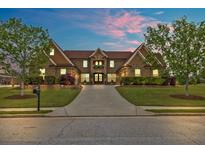 Beautiful brick home featuring a manicured lawn, lush landscaping, and an extended driveway at 401 Sara Ct, Loganville, GA 30052