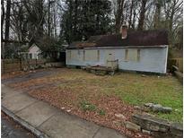 Modest single-story home with boarded windows, awaiting restoration and transformation at 1254 Campbellton Sw Rd, Atlanta, GA 30310