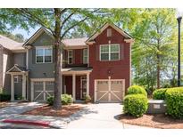 Two-story townhome featuring a brick facade, attached garage and manicured landscaping at 1396 Dolcetto Nw Trce # 12, Kennesaw, GA 30152