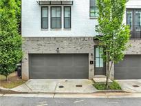 Modern townhome featuring painted brick and stone exterior with a two-car garage at 215 Arizona Ne Ave # 6, Atlanta, GA 30307