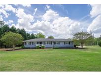 Charming single-story home with a well-maintained lawn, classic shutters, and mature landscaping at 220 Pitts Chapel Rd, Newborn, GA 30056