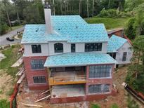 An exterior view of a house under construction, featuring a brick facade and a large sunroom area at 469 Emily Reed Ln, Atlanta, GA 30342