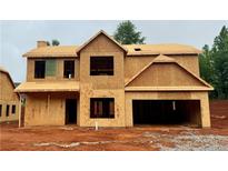 Unfinished two-story home exterior showing the framework and initial stages of construction, including the garage at 492 Charleston Pl, Villa Rica, GA 30180