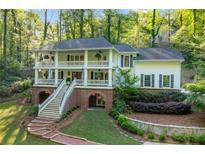 Charming two-story home boasts a spacious double porch, brick accents, and mature trees at 4094 Norton Se Pl, Smyrna, GA 30082
