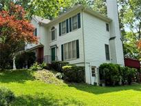Charming home featuring a lush lawn, mature trees, and classic architectural design with green shutters at 602 Springharbor Dr, Woodstock, GA 30188