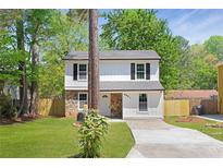 Charming two-story home with stone accents, black shutters and a well-maintained front yard at 6891 Hickory Log Rd, Austell, GA 30168