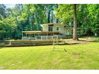 Charming home featuring a spacious front yard, covered patio, and complemented by the natural beauty of mature trees at 4882 Rock Haven Sw Dr, Lilburn, GA 30047