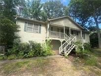 Charming home featuring a front porch and surrounded by lush greenery at 408 Walnut Dr, Woodstock, GA 30189