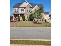 Beautiful brick two-story home boasts a manicured lawn, colorful flower beds and a welcoming entrance at 134 Sierra Cir, Woodstock, GA 30188