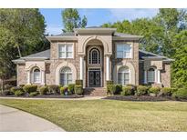 Beautiful two-story brick home with manicured lawn and an arched entryway with double doors at 4855 Regency Sw Trce, Atlanta, GA 30331