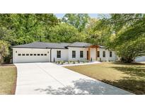 Charming renovated ranch-style home with white brick, black trim, new driveway and two car garage at 2327 Doreen Ne Ct, Atlanta, GA 30345