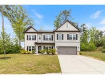 Charming two-story home with a manicured lawn and attached two car garage at 5103 Woodline View Ln, Auburn, GA 30011