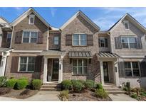 Charming townhome exterior with brick facade, shuttered windows, and well-maintained landscaping at 1671 Hammock Dr, Smyrna, GA 30080