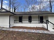 Charming single-story home with a covered porch and black accents on a bright day at 1805 Wiggins Sw Cir, Conyers, GA 30094