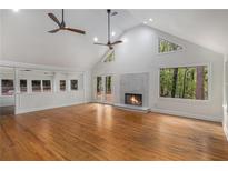 Spacious living room features high ceilings, modern ceiling fans, a fireplace, and lots of natural light at 535 Emerald Pkwy, Sugar Hill, GA 30518