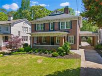 Charming brick two-story home featuring a landscaped yard, covered porch, and convenient carport at 1063 Hudson Ne Dr, Atlanta, GA 30306