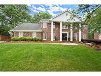 Stately brick home featuring a manicured lawn, mature trees and classic architectural details at 1328 Wyntercreek Rd, Atlanta, GA 30338