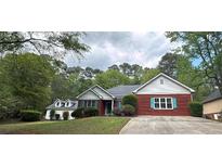 Charming brick home with green shutters, well-maintained lawn, and lush trees at 1721 Druids Se Xing, Conyers, GA 30013