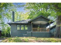 Charming brick bungalow featuring a covered front porch and lush green landscaping at 1395 Hartford Sw Ave, Atlanta, GA 30310