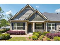 Charming home featuring a well-manicured front yard, black shutters, and a brick entryway, creating a welcoming curb appeal at 1410 Bluestone Dr, Cumming, GA 30041