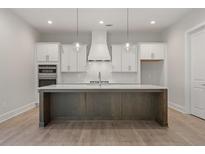 Modern kitchen features a spacious island, white cabinets, and stainless steel appliances at 1005 Liberty Springs Dr, Woodstock, GA 30188