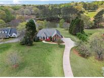 Expansive aerial view of estate home with long driveway, pond, and lush green lawn at 4790 Hyde Rd, Cumming, GA 30040