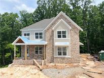 New construction home shows a charming brick facade with complementary gray trim and unfinished landscaping at 1025 Liberty Springs Dr, Woodstock, GA 30188