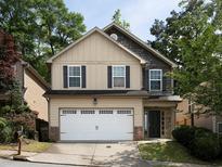 Charming two-story home featuring a two-car garage, neutral siding and well-maintained landscaping at 415 Village Way, Woodstock, GA 30188