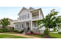 Charming home showcasing a stone facade, dual balconies, manicured landscaping, and a welcoming walkway at 2004 Haley Walk, Woodstock, GA 30188