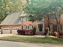 Charming brick home featuring an attached two-car garage and mature landscaping at 2355 Twelvestones Dr, Roswell, GA 30076