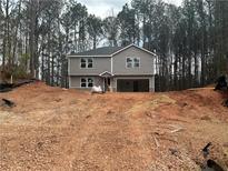 New construction two-story home with gray siding and an attached two-car garage on a wooded lot at 35 Emerald Ln, Covington, GA 30014