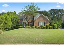 Well-manicured lawn and landscaping enhance this two-story brick home's curb appeal at , Cumming, GA 30041