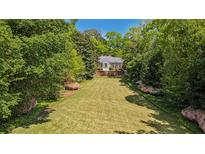Lush front yard with manicured lawn and charming brick home, framed by mature trees and colorful azaleas at 289 W Paces Ferry Nw Rd, Atlanta, GA 30305