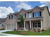 Charming two-story brick home with a welcoming front porch and manicured lawn at 3325 Linstead Ct, Loganville, GA 30052