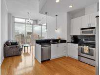 Bright kitchen featuring stainless steel appliances, black subway tile backsplash, and hardwood floors, with a city view at 860 Peachtree Ne St # 2815, Atlanta, GA 30308