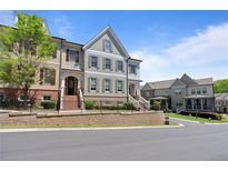 Attractive townhome exteriors feature brick and siding accents, complemented by manicured landscaping, and beautiful architectural details at 265 Trecastle Sq, Canton, GA 30114