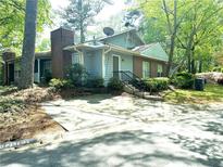 Charming two-story home with a brick chimney and a well-maintained front yard surrounded by lush trees at 4828 Westridge Dr, Norcross, GA 30093